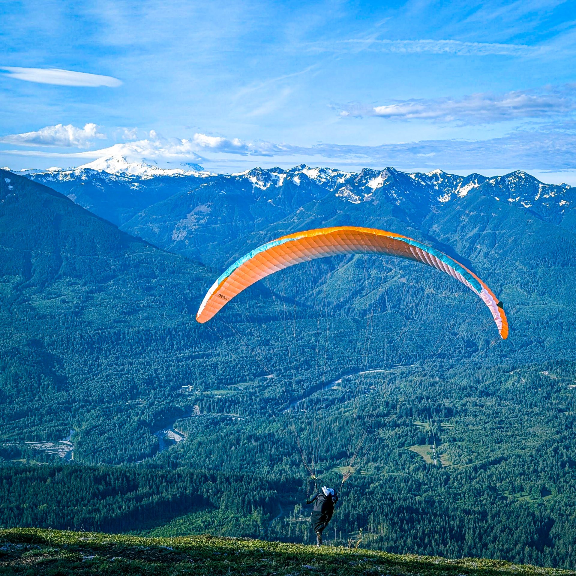 Paraglider in flight over the valley